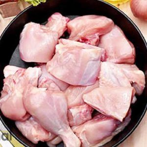 Raw chicken biryani cut and ingredients in a pan